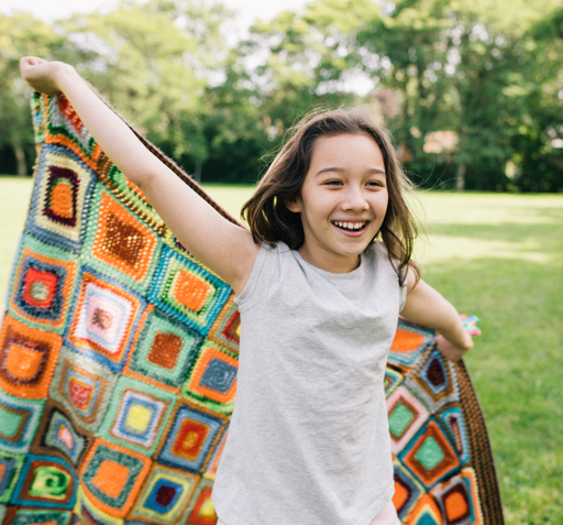 Smiling girl running with cape