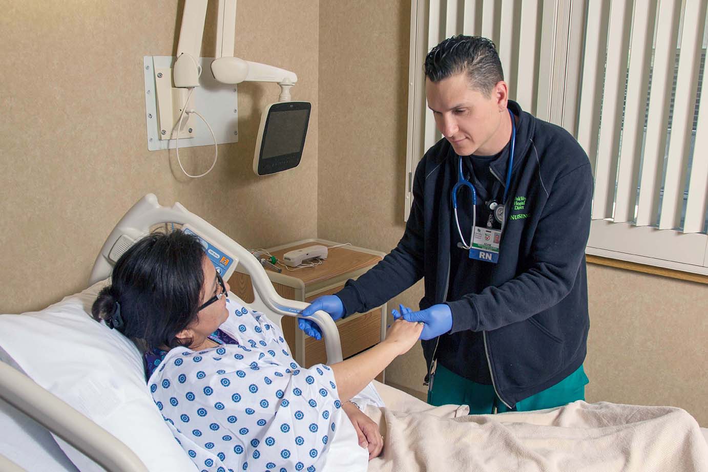 RN tending to a patient laying on a medical bed