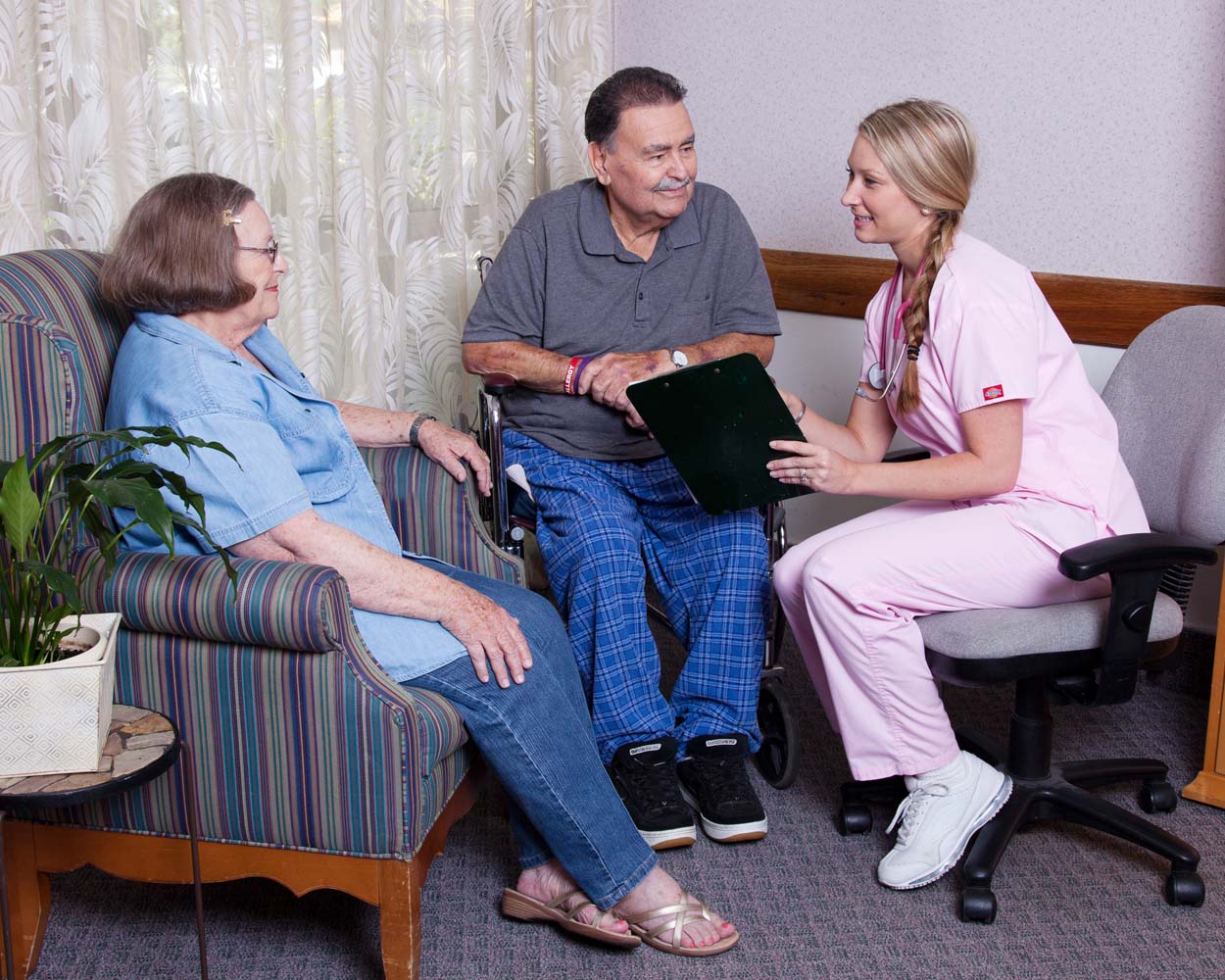 Nurse happily consoling elderly couple