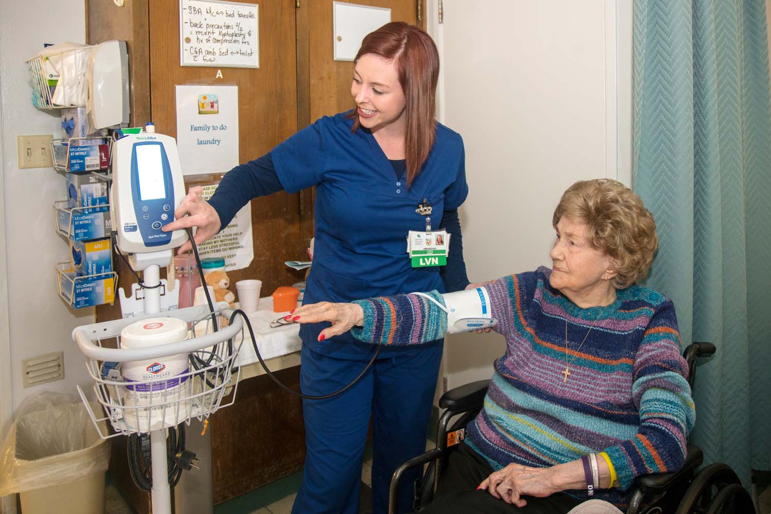 Nurse happily taking elders blood pressure