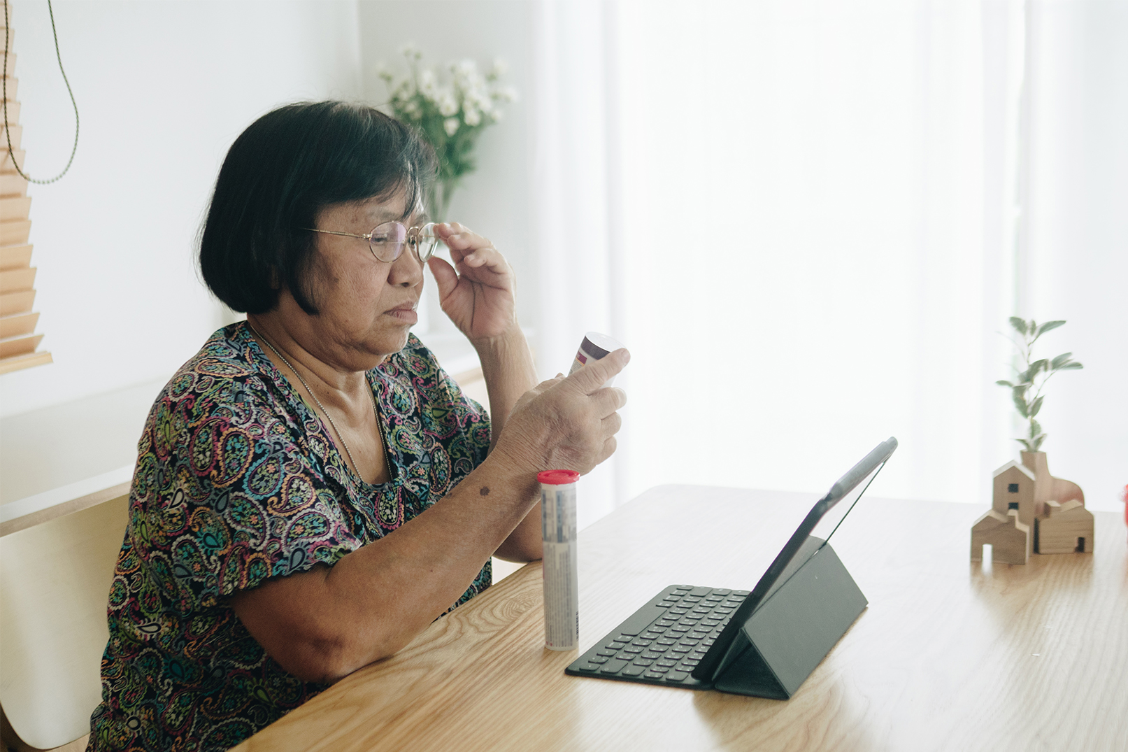 Woman looking at the detail of per medication bottle